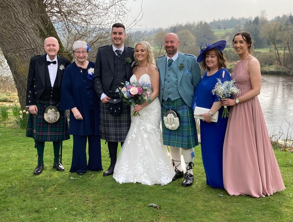 A Scottish wedding where the gentlemen are wearing kilts with varying tartans 